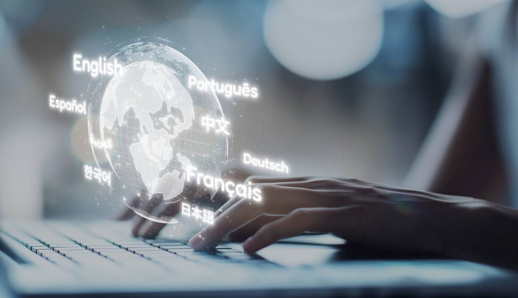 A person is typing on a laptop to various languages using technology